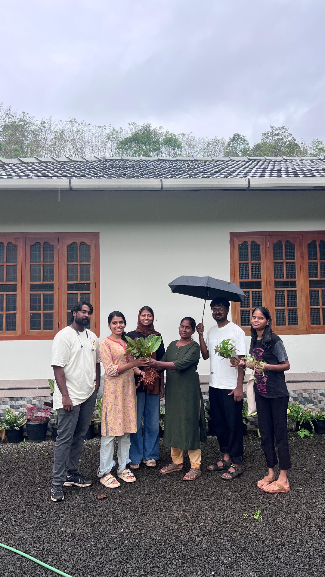 Ignite team with a local elder, sharing native saplings in the rain